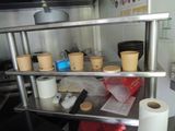 a metal shelf with cups and cups on it in a kitchen