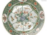 une assiette verte et blanche décorée de fleurs et d'oiseaux
