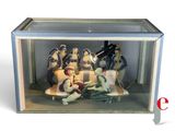 figurines of a group of people sitting on a couch in a glass case