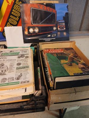 two boxes of books on a table next to a box of magazines