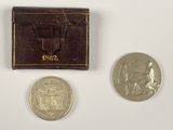 deux pièces et un petit portefeuille posés sur une surface blanche