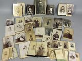 Un assortiment de vieilles photos d'hommes et de femmes est exposé sur une table