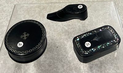 une boîte noire sur laquelle figure une horloge, ainsi que deux autres objets posés sur une table