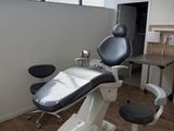a dentist ' s chair in the corner of the room
