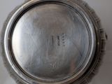 a silver plate with a silver lid on a glass table