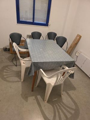 une table et des chaises dans une pièce avec une fenêtre bleue