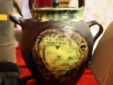 une théière marron et jaune posée sur une table rouge