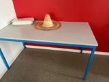 a small table with a hat on it in front of a red wall