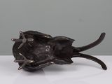 a small black object on a white table with a gray background
