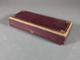 a small red box with gold trim on a table
