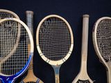 several tennis rackets are lined up against a black background