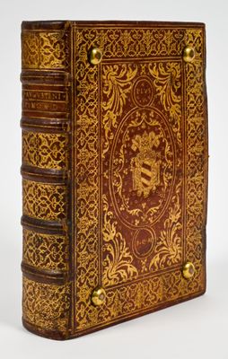 a brown and gold book sitting on top of a white surface
