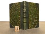 an old book with a green cover on a table