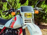 une moto rouge et blanche garée sur le bord de la route