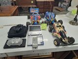 une table sur laquelle se trouvent un ordinateur portable, une télécommande et des petites voitures