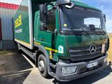 un camion vert garé devant un immeuble