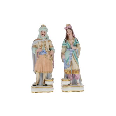 two figurines of a man and a woman dressed in costumes