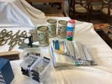supplies laid out on a bed in a room with a white sheet