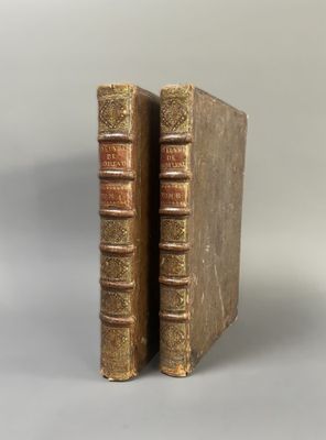 two old books sitting on top of each other on a table
