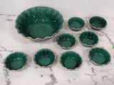 des bols en céramique verte et des bols à bordure dorée posés sur un plateau en marbre