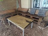 a couch and a table in a room with wood pallets on the ground