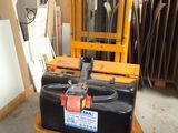 a forklift with a black container on it in a warehouse