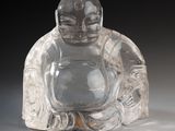 une figurine de Bouddha en verre posée sur une table