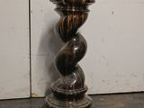 a black and brown candle that is on a table