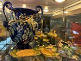 une vitrine en verre sur laquelle est posé un vase bleu
