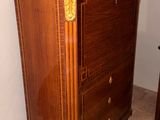 a cabinet in the corner of a room with a toilet in the corner