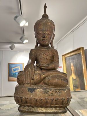 une statue de Bouddha assis sur une table en verre