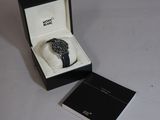 une montre en noir et blanc dans un coffret posé sur une table
