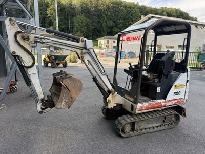 une petite pelleteuse garée sur le parking