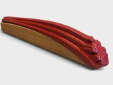 un objet rouge posé sur une surface blanche et muni d'une poignée rouge