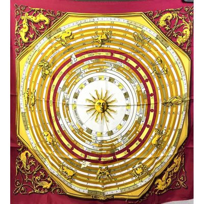 un gros plan sur une écharpe rouge et jaune ornée d'une horloge