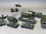 des véhicules militaires miniatures et d'autres véhicules sont exposés sur une surface blanche