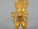gold figurine of a man holding a baby in his arms