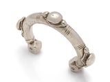 a close up of a silver cuff with a pearl on it