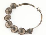 a close up of a silver bracelet on a white surface