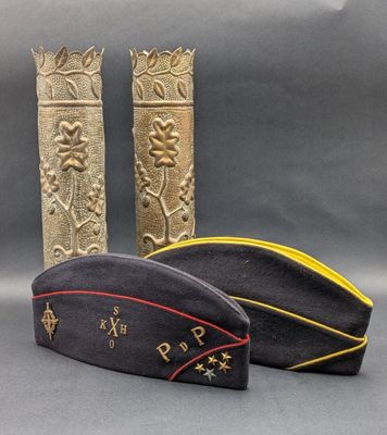 two military hats are sitting next to each other on a gray surface