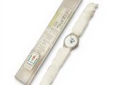 a watch that is sitting next to a tube of toothpaste