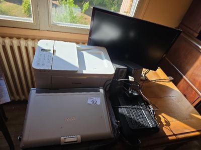 a laptop and a printer sitting on a desk in front of a window