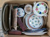 a cardboard box filled with assorted plates and bowls