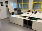 un bureau avec une chaise et un tableau blanc dans une pièce