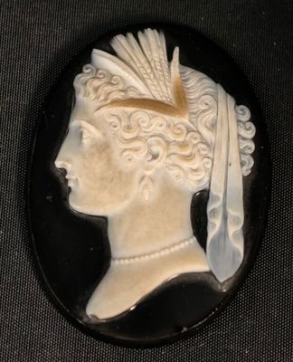 camée en noir et blanc représentant une femme avec une plume dans les cheveux