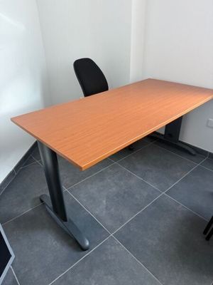 une photo représentant une table en bois avec deux chaises noires dans une pièce