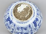 a blue and white vase with a gold lid