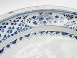 a blue and white plate with a flower design on it