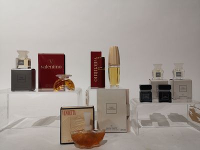 de nombreux parfums différents exposés sur une table blanche