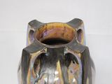 a black vase with a purple and yellow design on it